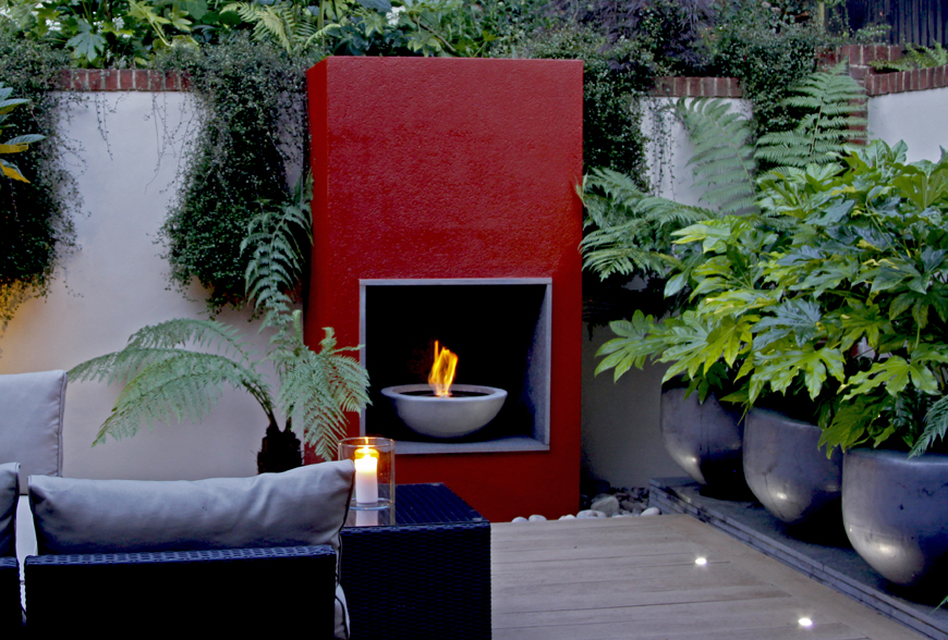 greencube plays with scale using large pots on a granite plinth in this modern garden in caterham, surrey
