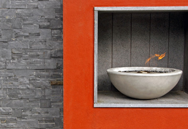 this garden design shortlisted for a national competition features tropical planting and a dramatic red firebowl feature wall